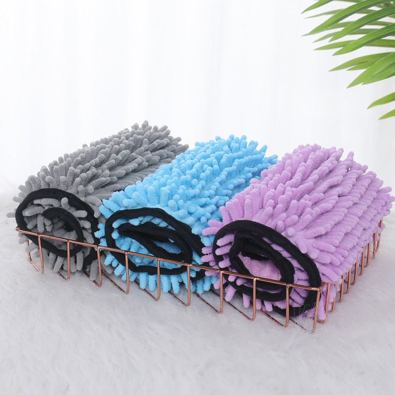 Set of three cleaning brushes in gray, blue, and purple on a white background with green leaves.