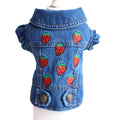A blue denim pet jacket with embroidered red strawberries on the front, displayed on a white mannequin torso against a white background.