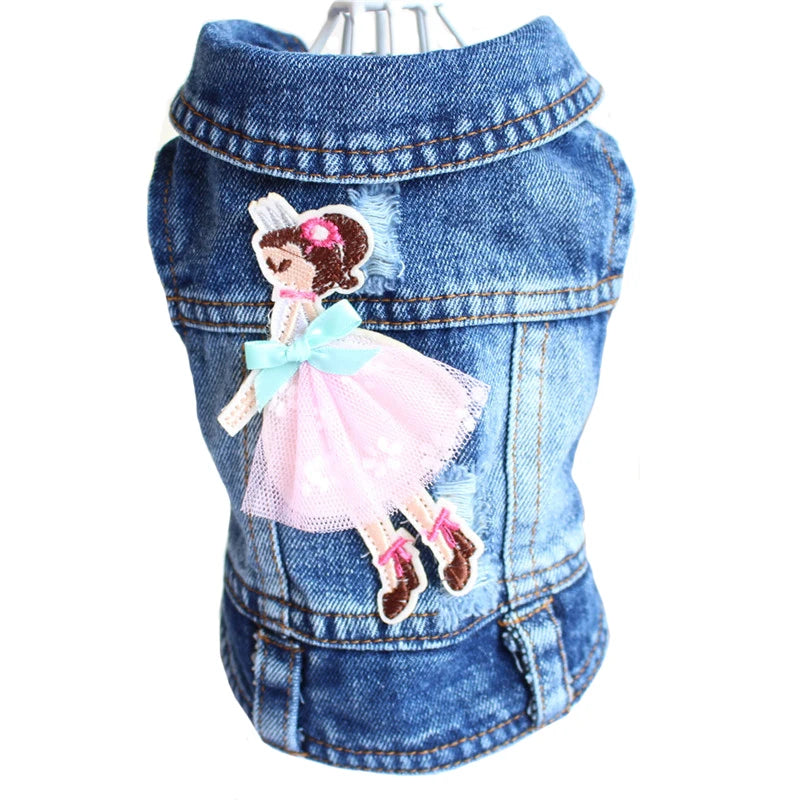 A blue denim pet vest with a decorative embroidered cartoon girl patch on the front, shown on a white background.
