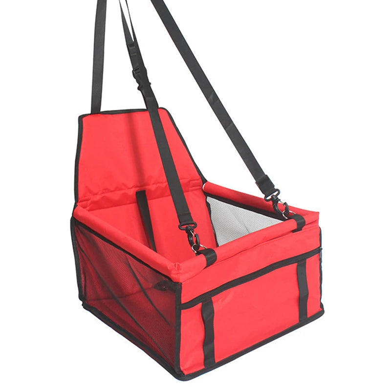Red pet seat carrier with black straps on a white background