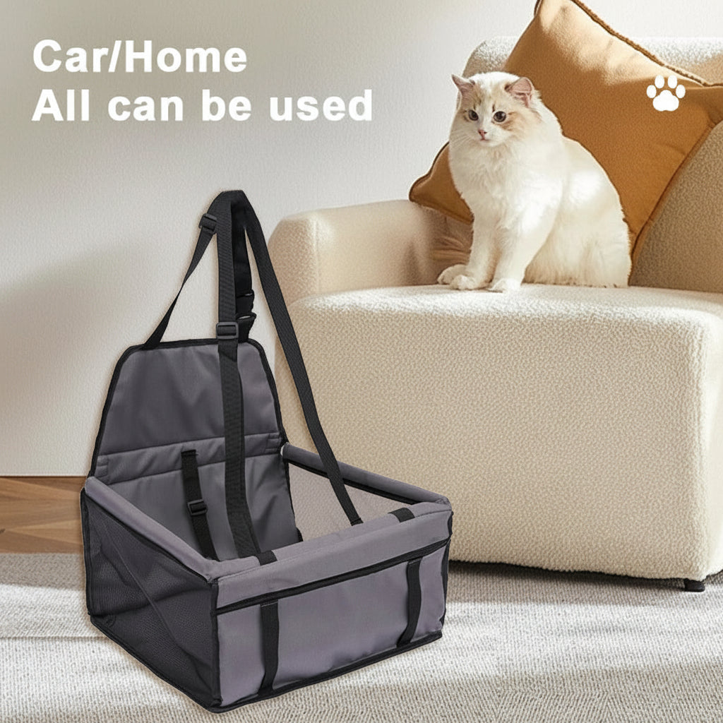 Gray pet seat cover with straps on a couch next to a white cat.
