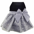 Children's dress with black top and gray skirt with snowflake pattern and large bow on a white background
